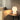 Witte tafellamp op houten tafel naast beige bank, moderne interieurverlichting.