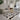 Pluche beige bank, zwart-wit vloerkleed, moderne lamp, woonkamerinrichting, Scandinavisch design.