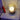 Glazen tafellamp met bolvormig ontwerp op houten nachtkastje, sfeerverlichting, modern interieur.