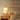 Cesta tafellamp op nachtkastje, houten frame, warme gloed, moderne slaapkamerverlichting.