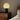 Moderne tafellamp met witte glazen kap en zwarte basis op houten nachtkastje in slaapkamer.