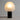 Moderne tafellamp met witte glazen kap en zwarte basis, sfeerverlichting, eigentijds design.