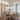 Houten eettafel met vier stoelen en hanglampen in moderne eetkamer, Scandinavisch design.