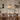Eetkamer met houten tafel, vier stoelen, hanglamp, decoratieve planten, moderne inrichting.