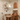 Houten eettafel met vier stoelen, hanglamp en wanddecoratie in gezellige eetkamer.