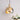 Gouden hanglamp met moderne bolvorm, glanzende afwerking, naast witte bloemen in vaas.