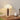 Vintage tafellamp met houten voet en witte kap op houten dressoir, sfeerverlichting.