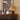 Bruine houten tafellamp met geplooide kap op vintage kast, moderne interieurdecoratie.