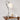 Ribbel keramische tafellamp, wit, modern design, op houten tafel met tijdschrift en kaars.