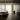 Moderne woonkamer met glazen wand, minimalistisch interieur, beige tinten, designmeubels.