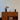 Vintage houten dressoir met zwarte tafellamp en decoratieve accessoires, retro interieurstijl.