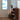 Vintage houten dressoir met moderne tafellamp, minimalistisch interieur, zonlicht door raam.