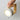 Hand houdt moderne grijze tafellamp met houten handvat vast, minimalistisch design.