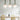 Drie lelievormige hanglampen boven moderne eettafel, wit en groen design.