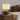 Textuur keramische tafellamp met witte kap op houten kast, moderne interieurdecoratie.