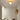 Gouden plafondlamp met moderne uitstraling in minimalistische witte ruimte.