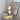 Tafellamp met dubbele chromen bollen, moderne designverlichting, naast kunstposter en boeken.