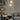 Gouden wandlamp modern design in woonkamer met grijze muur en boekenplank.