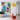 Moderne woonkamer met kleurrijk abstract schilderij, groene fauteuil en rode konijn sculptuur.