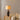 Bruine keramische tafellamp met beige kap op houten tafel, moderne interieurdecoratie.