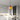 Oranje hanglamp boven moderne keuken met marmeren eiland en grijze barkrukken.