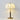 Witte stoffen tafellamp met houten voet en messing details, elegante verlichting voor interieur.