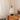 Witte peren-vormige tafellamp met ingebouwde batterij op houten kast, modern interieur.
