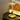 Moderne messing tafellamp met glazen kap op houten tafel, naast New York poster.