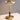 Gouden tafellamp met glazen kap, modern design, houten details, sfeerverlichting.