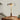 Moderne tafellamp met glazen kap en messing voet, houten details, geschikt voor woonkamer.