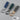 Drie leren sleutelhangers in blauw, groen en grijs met metalen ringen en schroevendraaier.