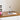 Glazen tafellamp op bureau met open boek en bloemen, moderne verlichting, transparant design.