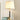 Gouden tafellamp met witte kap op houten tafel, klassieke stijl, interieurverlichting.