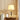 Gouden tafellamp met witte kap op houten tafel, moderne verlichting, interieurdecoratie.