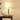 Gouden tafellamp met witte kap op houten tafel, moderne verlichting, interieurdecoratie.