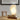 Moderne witte tafellamp met golvend ontwerp, sfeerverlichting, houten basis, minimalistisch interieur.