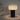 Moderne tafellamp met zwarte basis en geribbelde witte kap, sfeerverlichting, minimalistisch design.