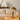 Gouden tafellamp op houten tafel, moderne inrichting, beige bank, decoratieve buste.