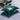 Twee groene satijnen kussens met bloemenprint op een bed, decoratieve slaapkameraccessoires.