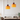 Twee oranje hanglampen boven eettafel, modern interieur, glazen lampenkappen, sfeerverlichting.