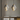 Twee moderne glazen hanglampen boven houten tafel, industrieel design, goud en zilver.