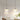 Twee moderne hanglampen met witte kappen boven eettafel, minimalistisch interieurontwerp.