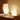 Twee moderne, witte tafellampen met golvend ontwerp op houten tafel, sfeerverlichting.