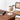 Beige tafellamp op houten bureau naast rieten stoel, modern design, interieurdecoratie.