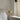 Beige tafellamp Valencia op witte tafel naast bank, modern design, minimalistisch interieur.