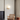 Moderne wandlamp met ronde glazen bol en houten basis in minimalistisch interieur.