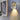 Moderne wandlamp met glazen kap, LED-verlichting, gouden afwerking, naast bloemenkunst.