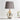 Grijze tafellamp met zilveren keramische voet, moderne woondecoratie, elegante verlichting.