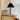 Zilveren tafellamp met zwarte geplooide kap op houten dressoir, moderne interieurdecoratie.