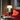 Witte marmeren tafellamp op houten tafel naast rode bank in moderne woonkamer.